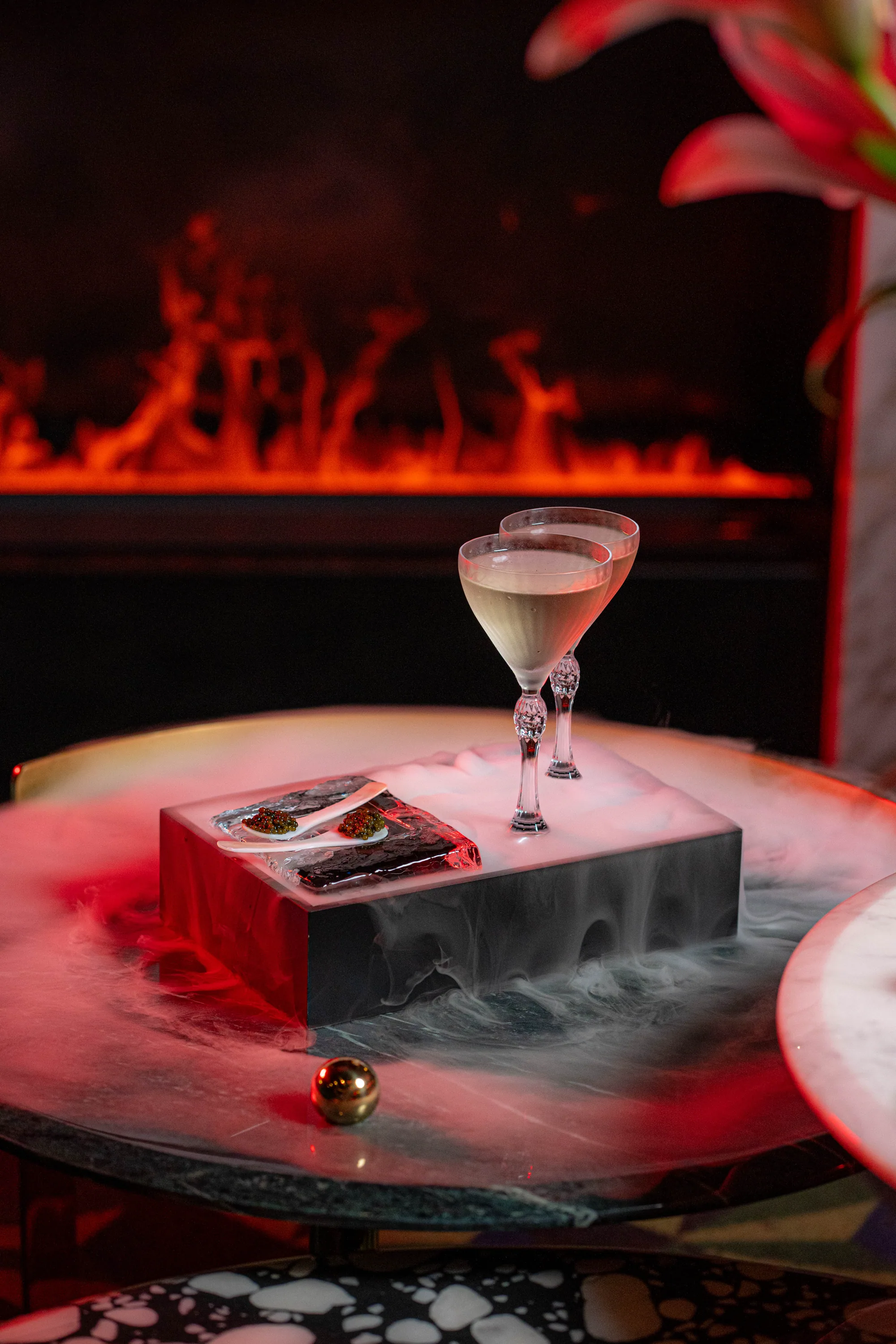 Cocktail presentation in the red-lit lounge