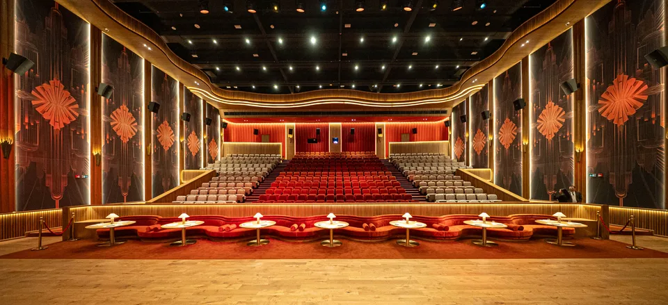 Cinema auditorium with red seats and illuminated decorative walls