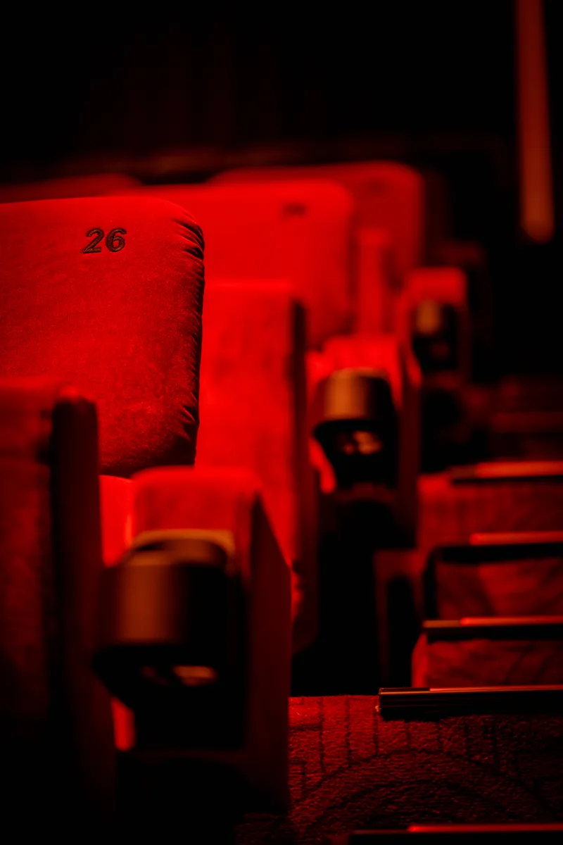 Red cinema seats with seat number 26 in focus