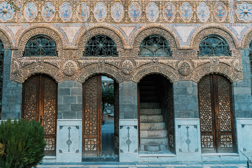 Carved stonework and wooden doors at Maktab Anbar