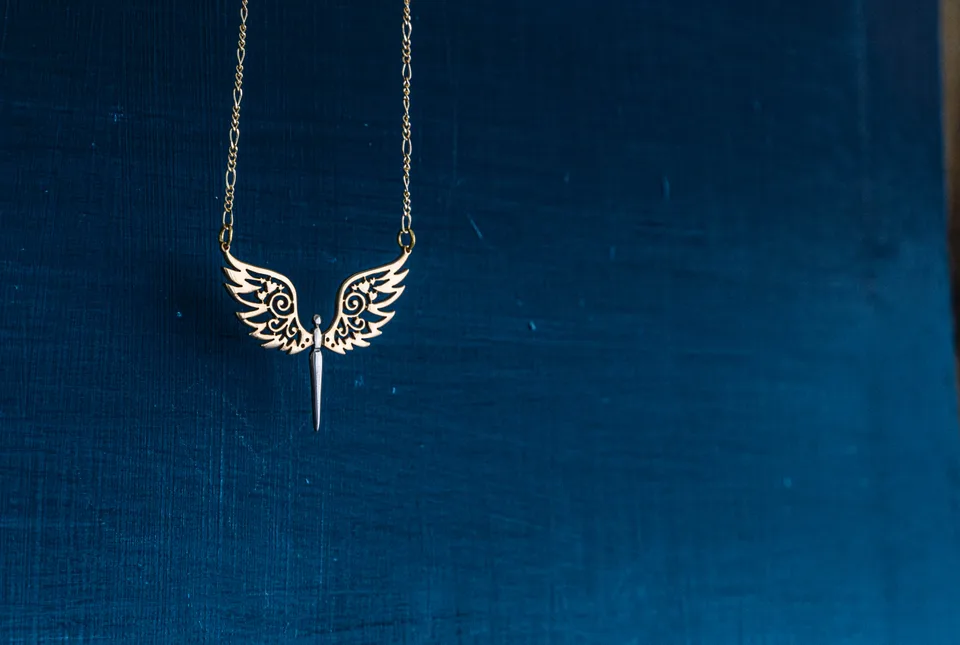 Winged pendant against a textured blue background